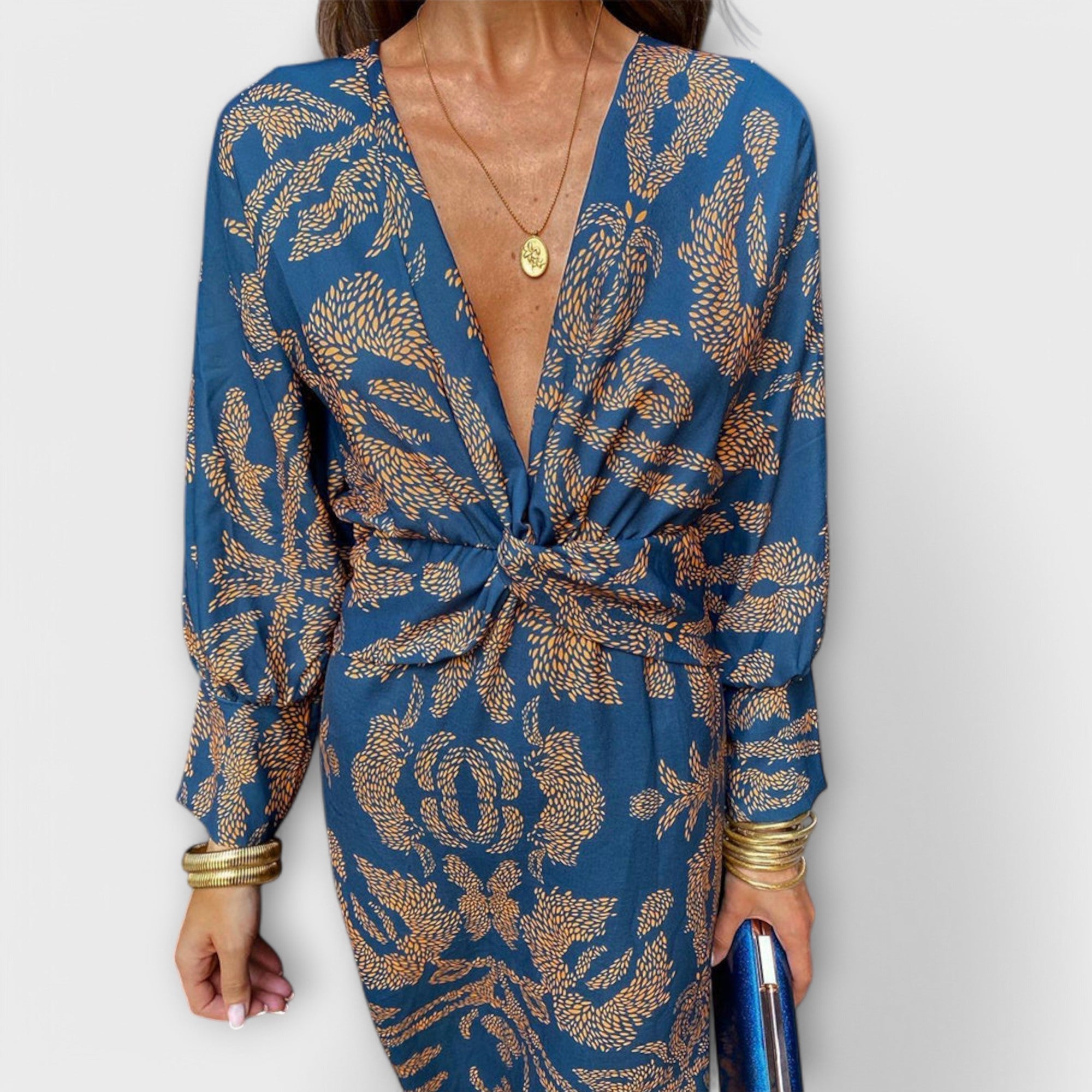 Elegantes Kleid mit langen Ärmeln, blau mit goldfarbenem Paisley-Muster, vorn geknotet