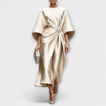 Langkleid aus schimmerndem Satin in Beige, drapiert mit Schmuckbrosche vorn