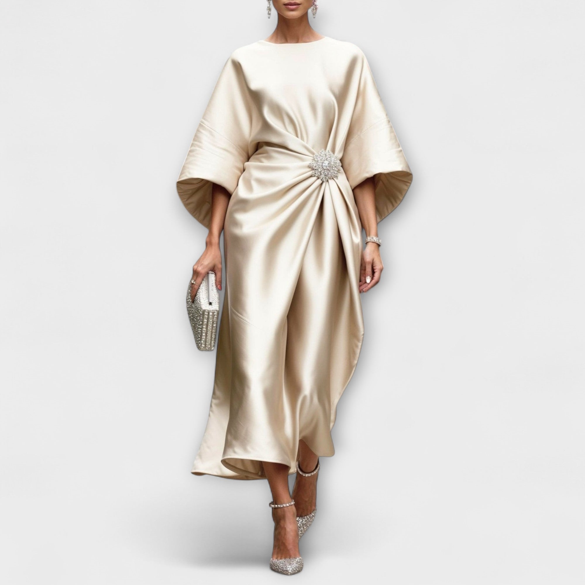 Langkleid aus schimmerndem Satin in Beige, drapiert mit Schmuckbrosche vorn