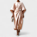 Langkleid aus schimmerndem Satin in Beige, drapiert mit Schmuckbrosche vorn