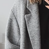 Grauer langer Mantel mit breitem Revers und Knopfleiste