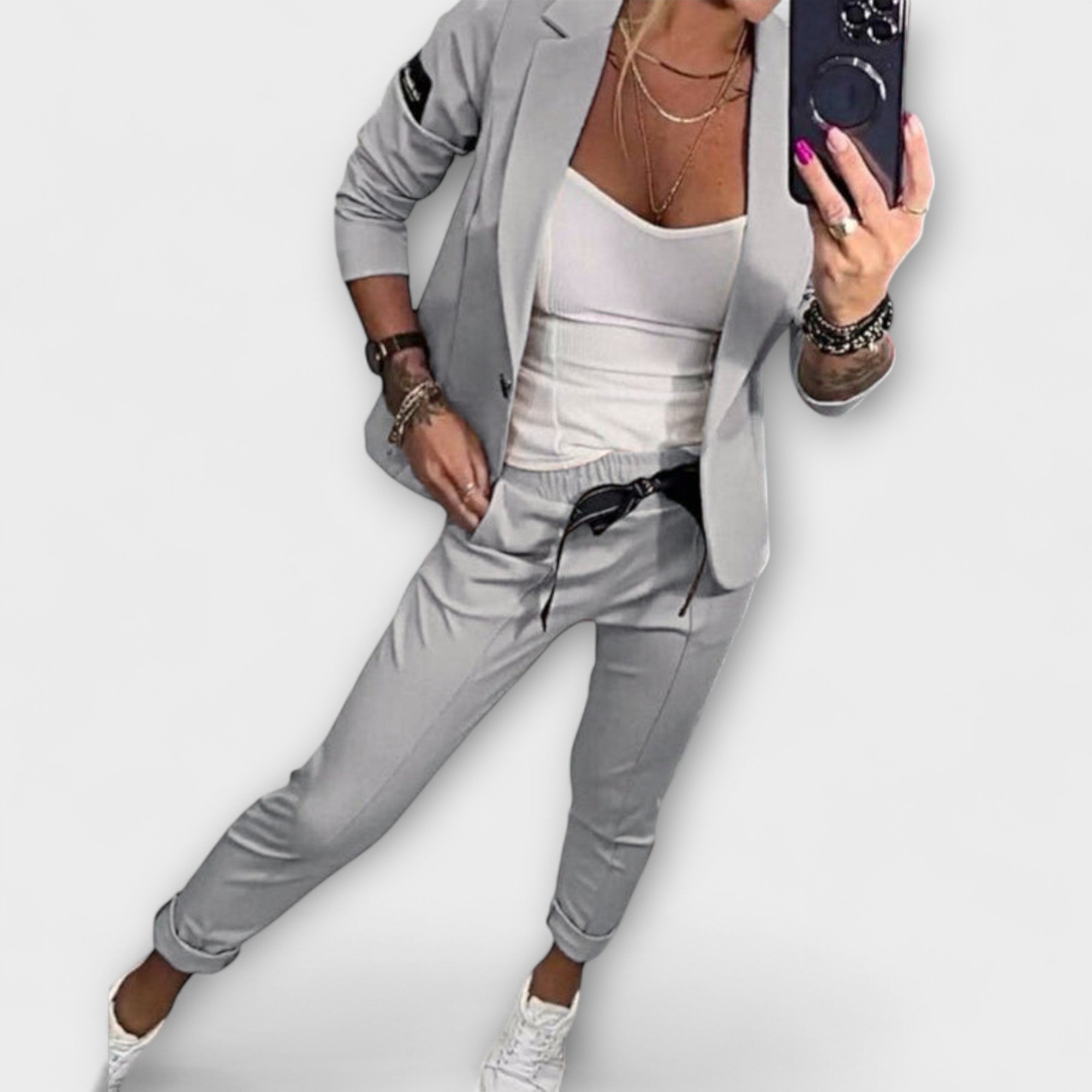 Koordiniertes Set: hellgraue Jacke und Hose mit weißem Top, offen getragen