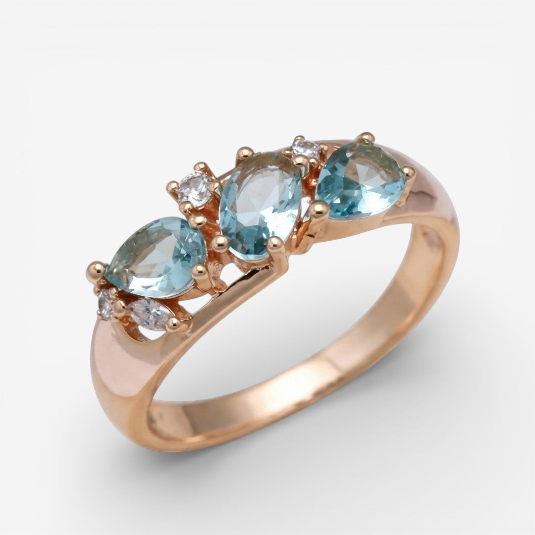 Roségoldfarbener Ring mit drei hellblauen Zirkonia-Steinen und klaren Akzenten