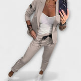 Koordiniertes Set: graue Jacke und Hose mit weißem Top, lässig geschnitten