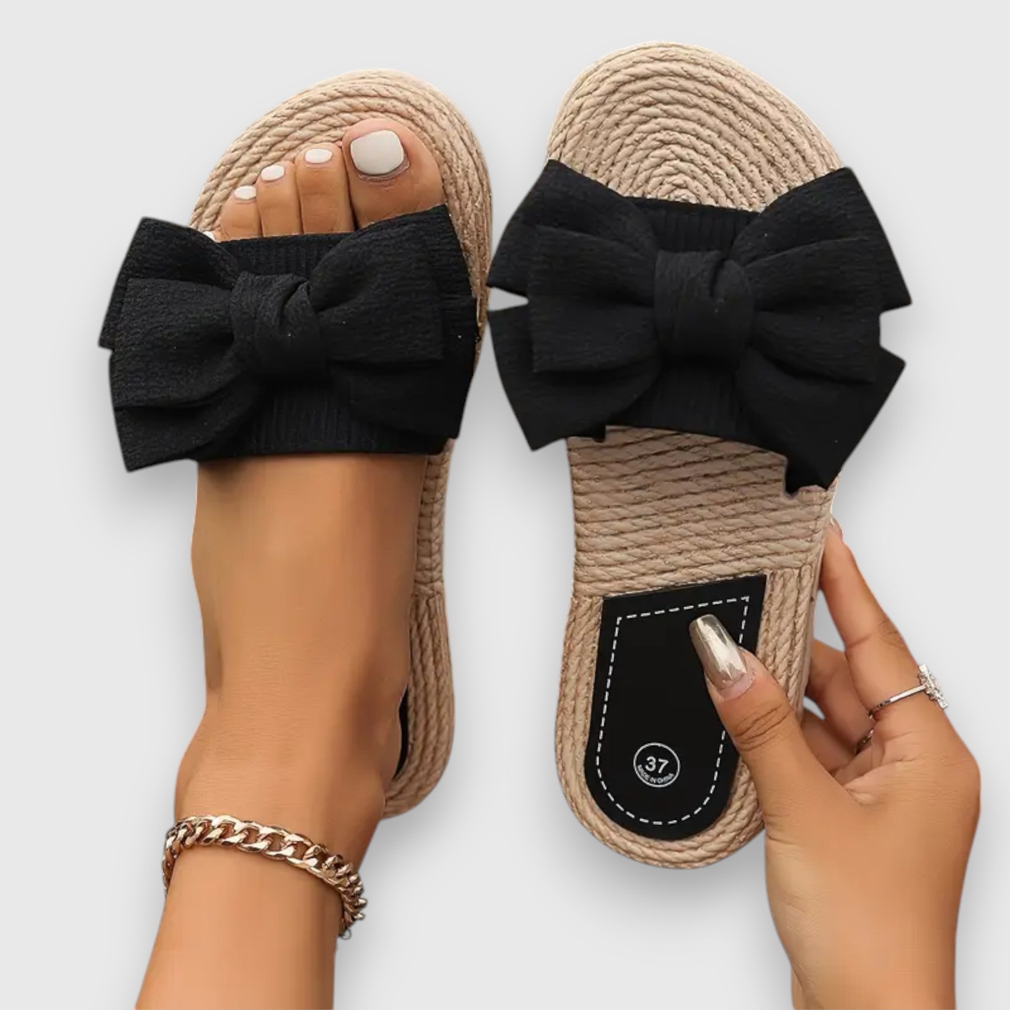 Zwei schwarze Flach-Sandalen mit Schleife, Jute-Sohle und seitlichem Markenetikett
