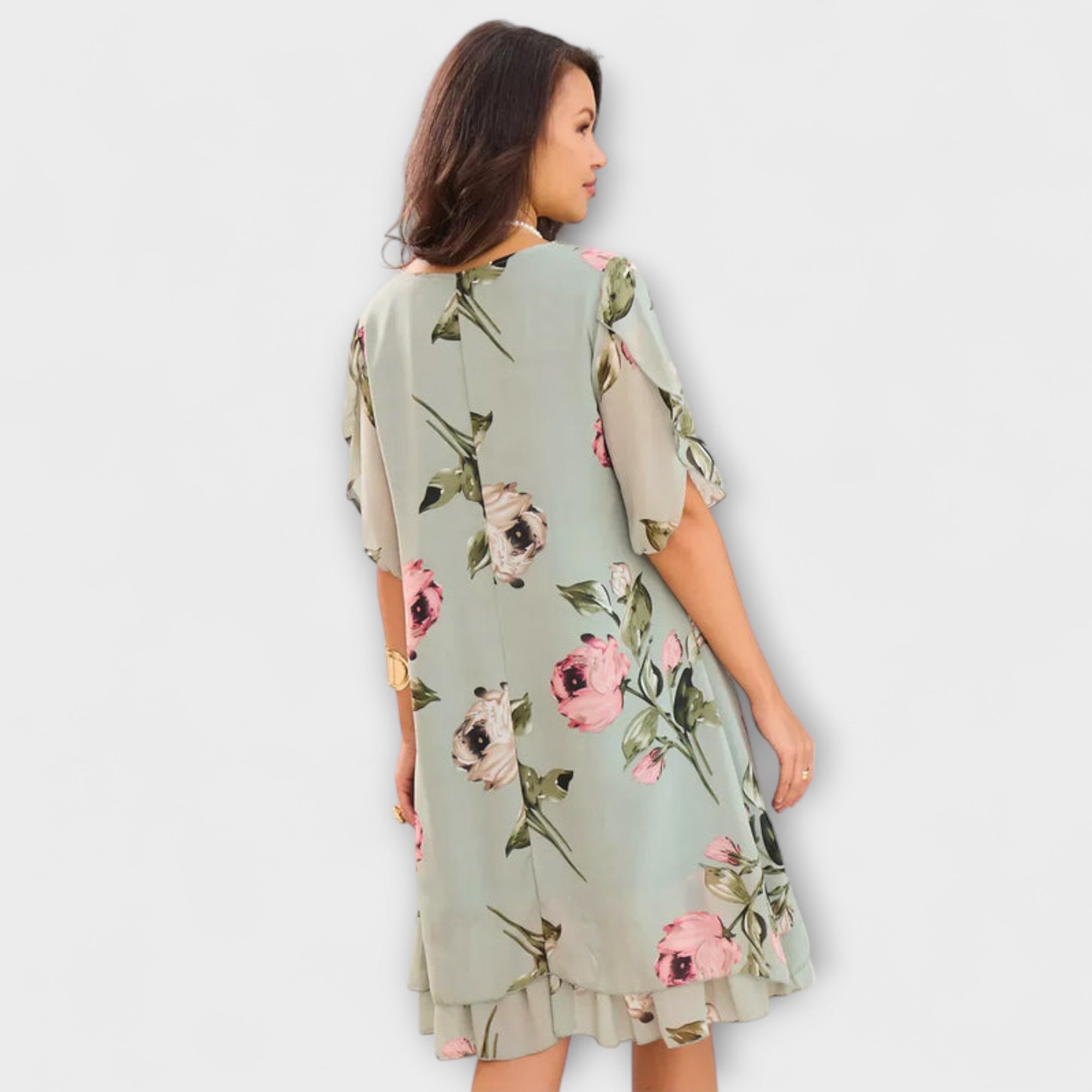 Elegantes Chiffonkleid in Hellgrün mit Blumenmuster, Rückansicht, kurze Ärmel, fließender Rock.