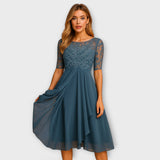 Blaues Kleid mit Rundhalsausschnitt, halbtransparentem Spitzeneinsatz und Rüschenrock