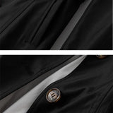 Schwarzer Windbreaker-Detail mit goldfarbener Knopfzier und Naht