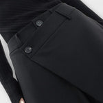 Asymmetrische Hose in Schwarz: Bund-Detail mit Knopfverschluss und glatter Vorderseite.