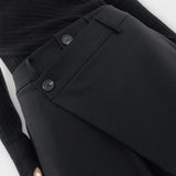 Asymmetrische Hose in Schwarz: Bund-Detail mit Knopfverschluss und glatter Vorderseite.