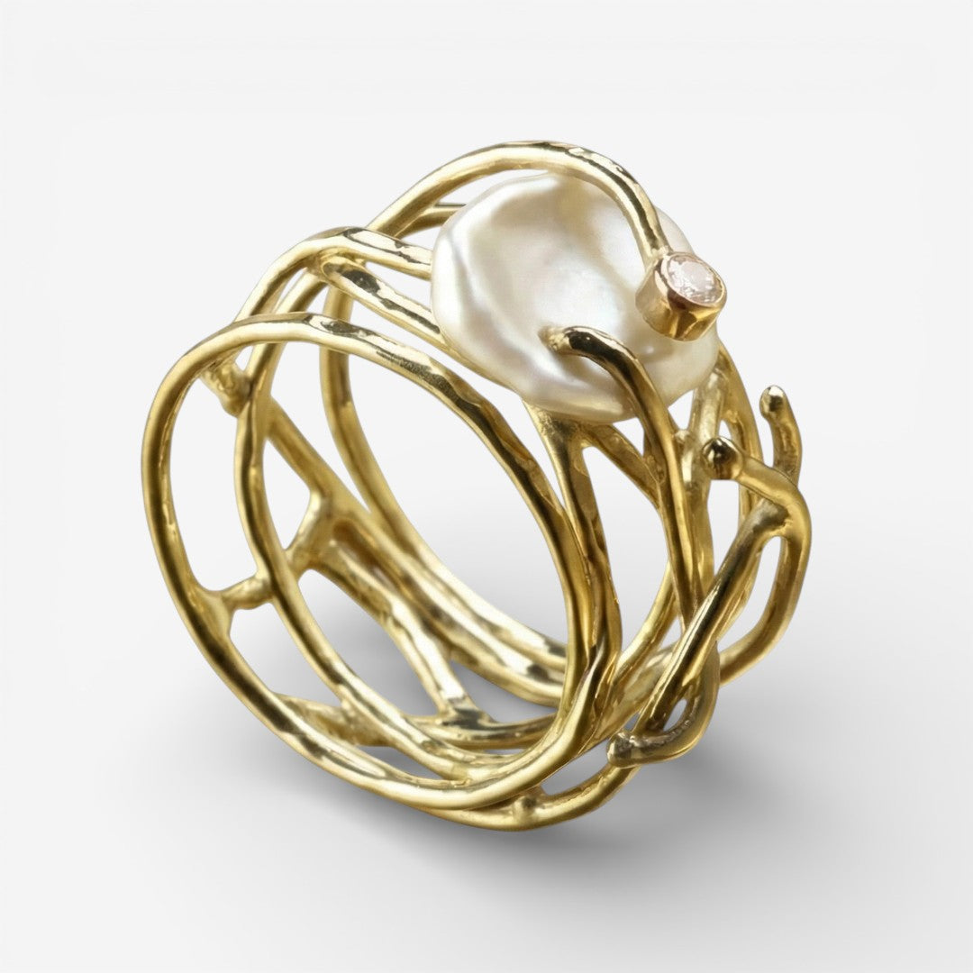 Goldfarbener Ring mit weißen Perlen und geschwungenem, offenem Design
