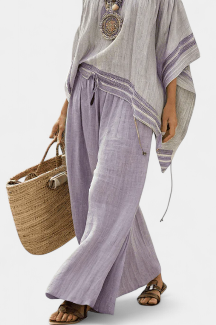 Lila weite Hose mit Bindeband, dazu lockeres Off-Shoulder-Top mit Streifenbesatz