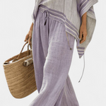Lila weite Hose mit Bindeband, dazu lockeres Off-Shoulder-Top mit Streifenbesatz