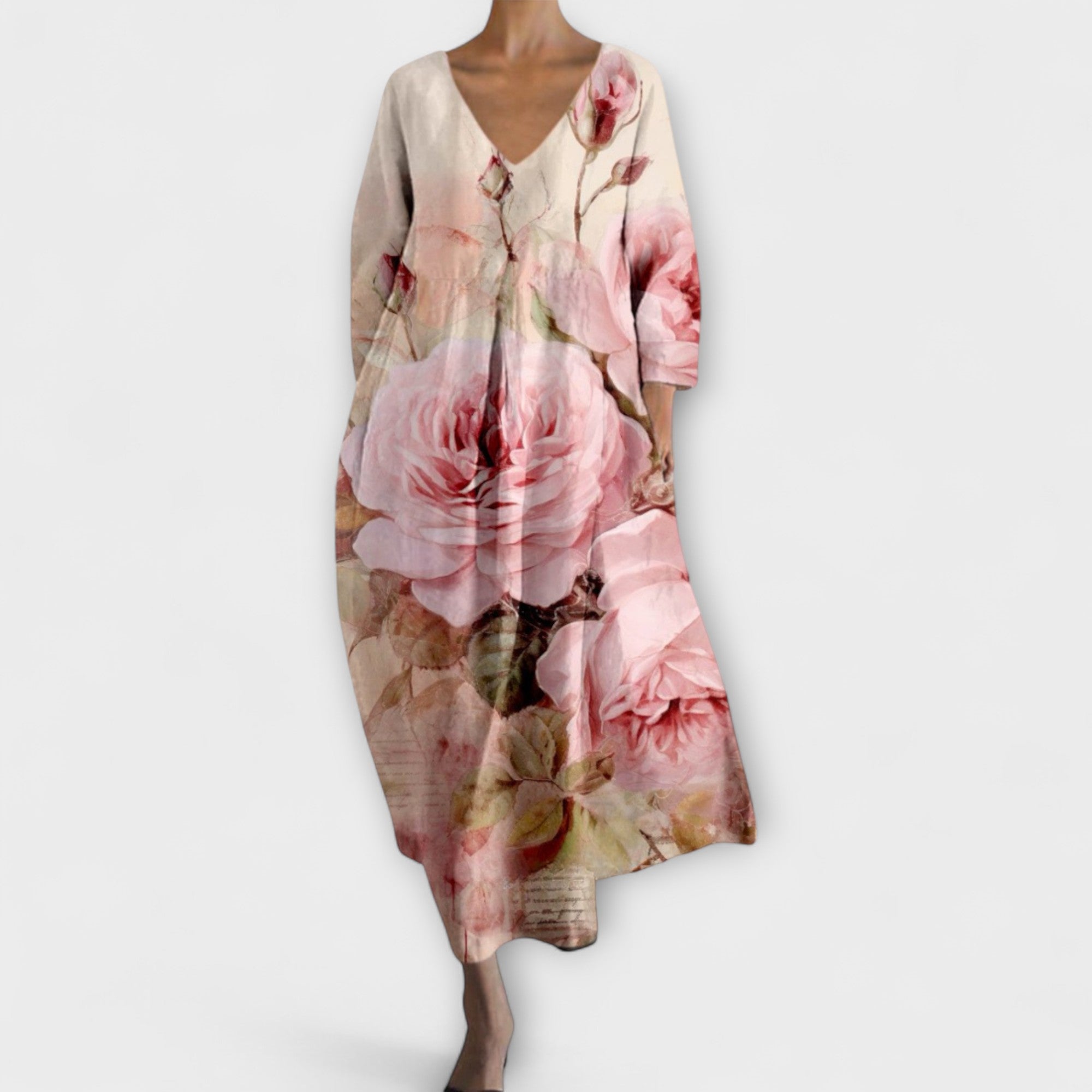 Langes Kleid mit V-Ausschnitt, 3/4-Ärmeln und großen Rosen im Pastellton.
