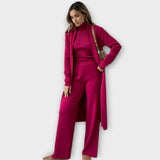 Fuchsiafarbener Dreiteiler am Modell: Turtleneck, weite Hose und langer Mantel