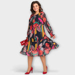 Rückenansicht: gemustertes Kleid mit langen Ärmeln und ausgestellt wirkendem Saum