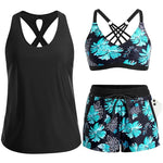Dreiteiliges Tankini-Set: schwarzes Tanktop, floraler Bikini-BH, Shorts.