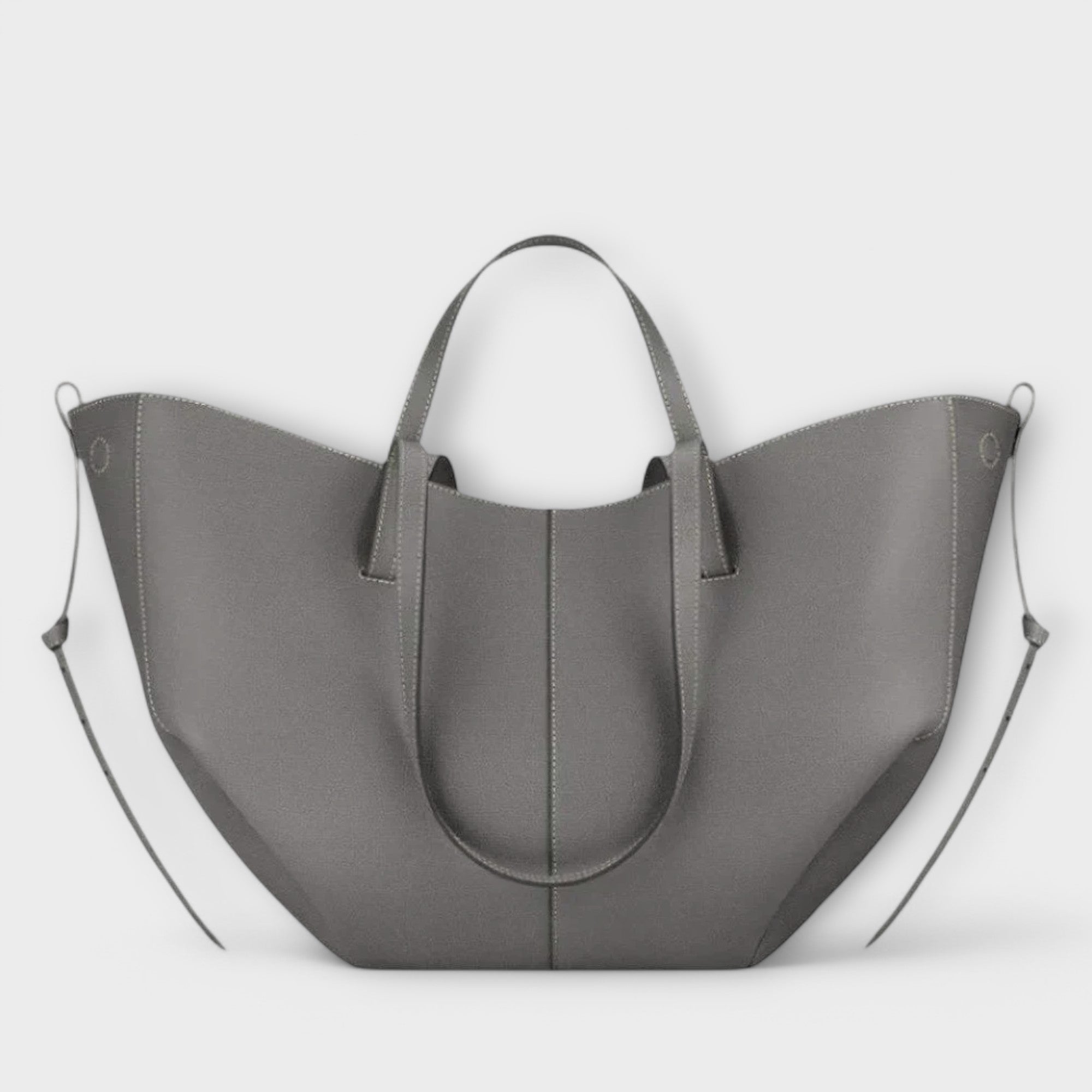 Graue Handtasche mit zwei Griffen, geschwungene Trageform und Mittelnaht.