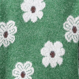 Pullover mit Reißverschlusskragen, grüner Strick mit weißem Blumenmuster in Nahansicht