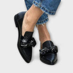 Schwarze Loafer mit Schleifenornament vorn und Schlangenlederstruktur, spitze Form