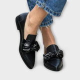 Schwarze Loafer mit Schleifenornament vorn und Schlangenlederstruktur, spitze Form