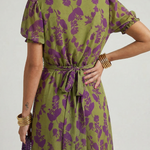 Rückansicht Midi-Kleid mit gebundenem Taillenband und lila Blütenmuster auf Olivgrün