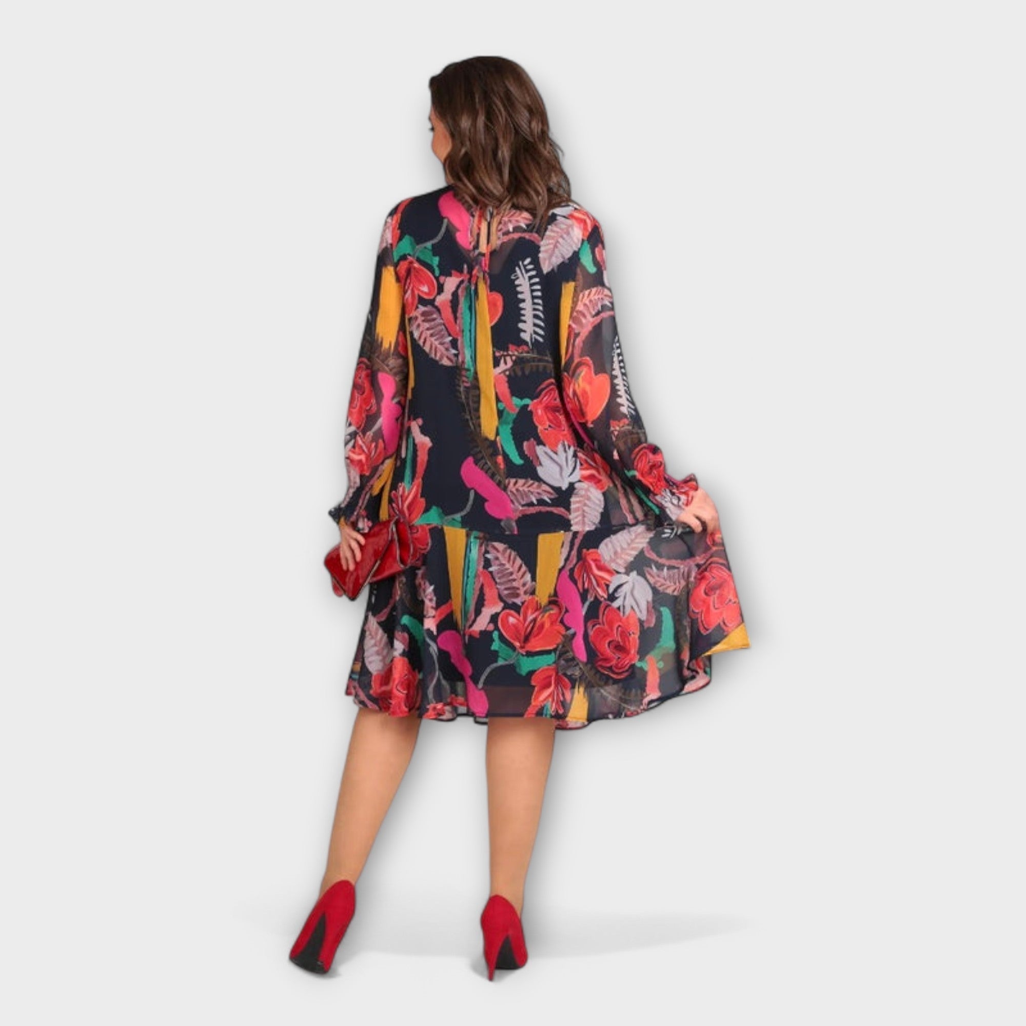 Rückenansicht: weites, gemustertes Kleid mit langen Ärmeln und fließendem Saum