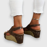 Plateau-Sandalen mit breitem Fußriemen, Nieten und Kork-Optikkeil, braun, offene Zehen.