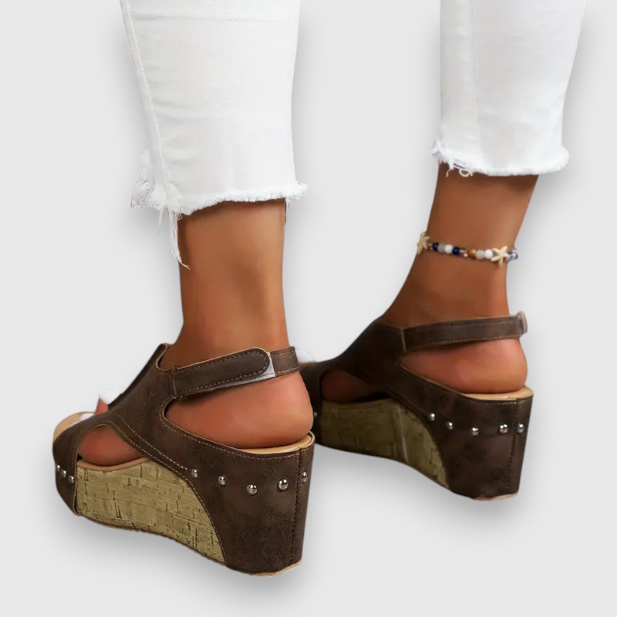 Plateau-Sandalen mit breitem Fußriemen, Nieten und Kork-Optikkeil, braun, offene Zehen.