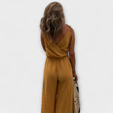 Gelber Jumpsuit mit gekreuztem Rückenausschnitt, Taillenbund, weitem Bein und Seitenschlitz.
