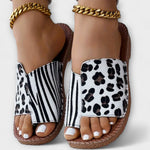 Sandalen mit goldener Kettenschließe, weißem Leopardenmuster und Zebrastreifen-Riemen.