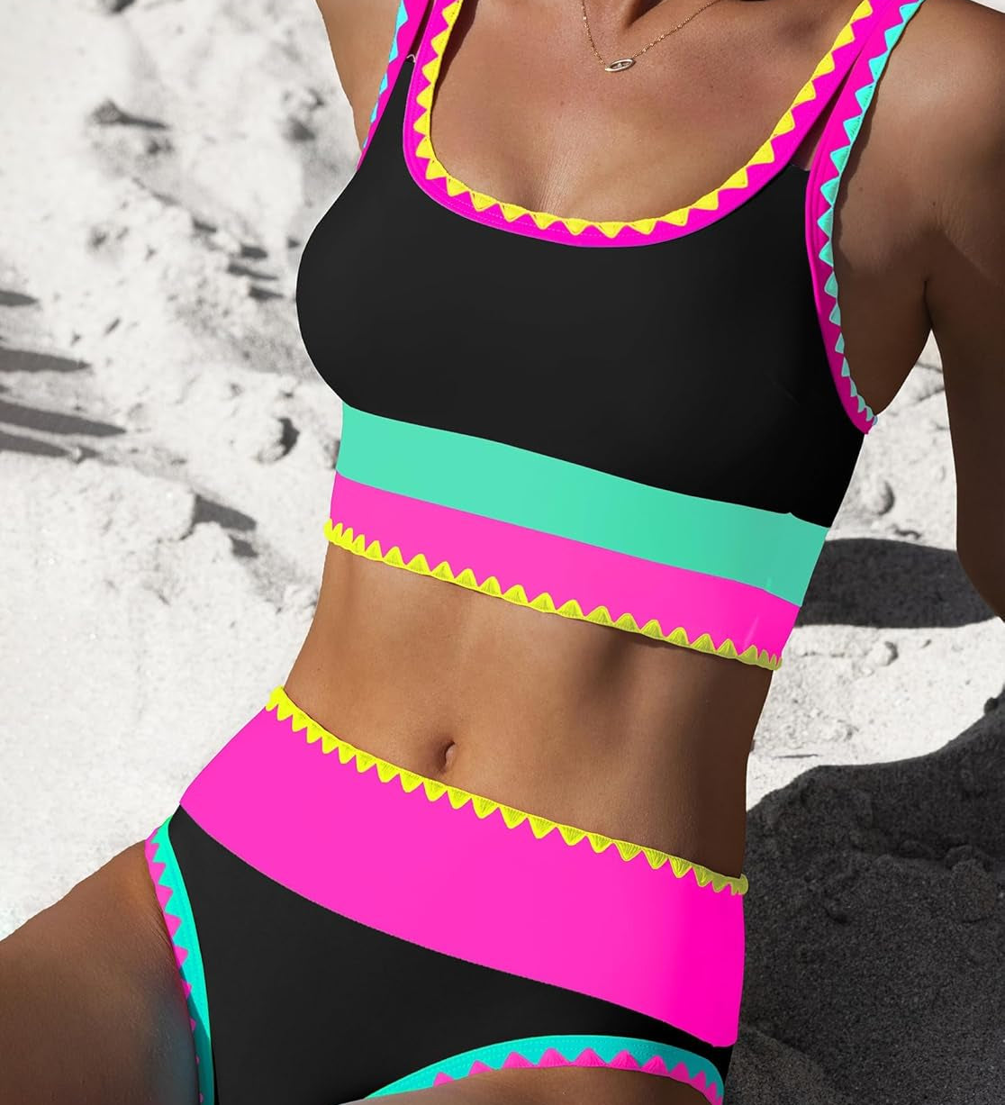 Bikinioberteil und -hose, schwarz mit pinken und türkisfarbenen Streifen und Zickzack