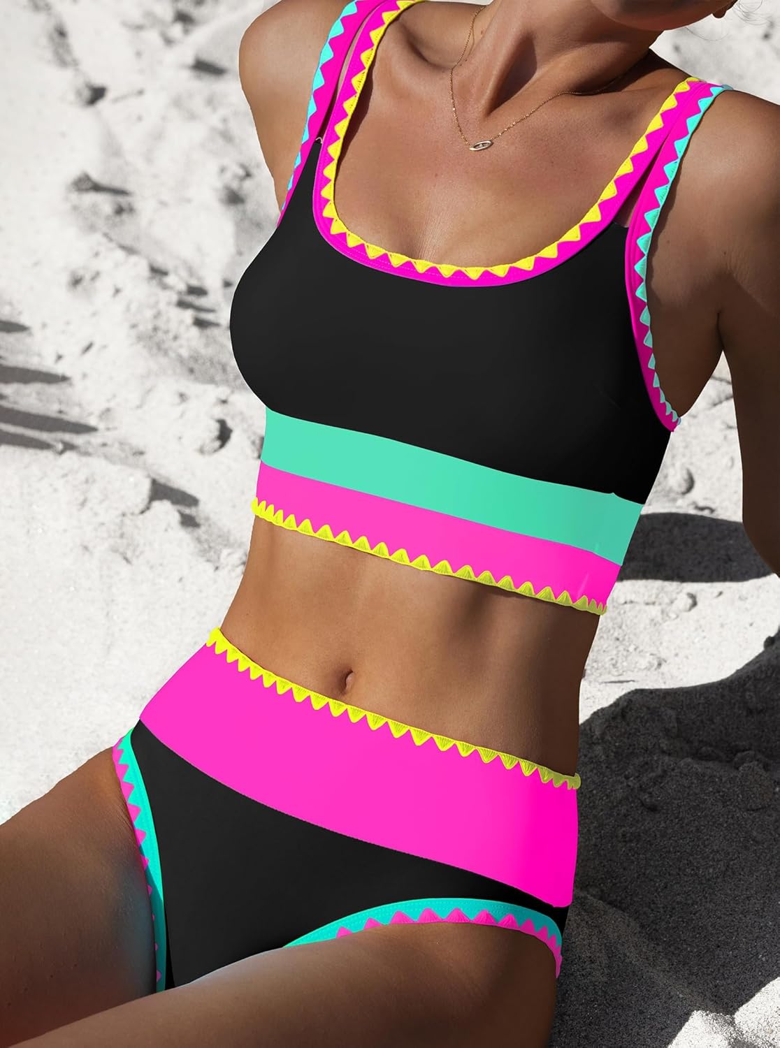 Bikinioberteil und -hose, schwarz mit pinken und türkisfarbenen Streifen und Zickzack