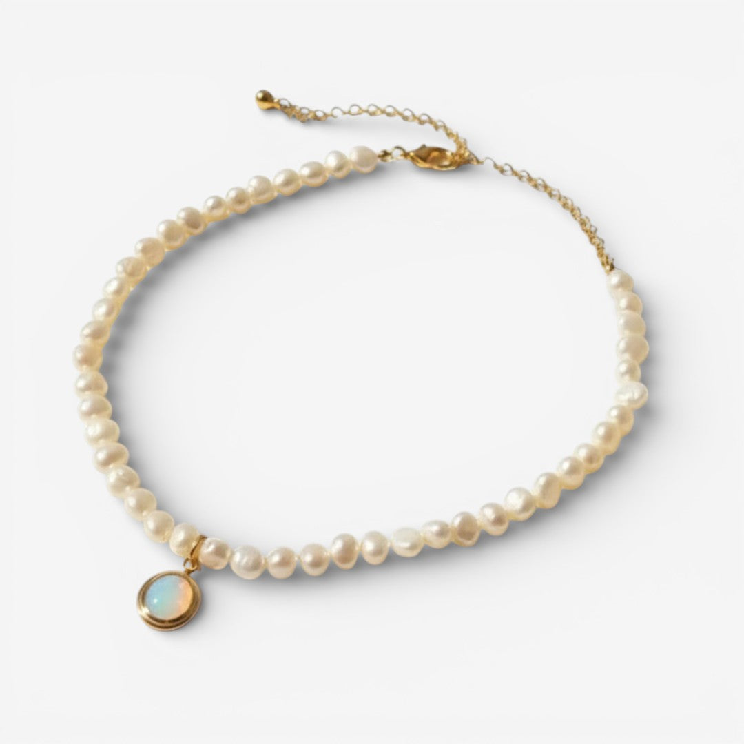 Perlenkette mit goldfarbener Kette und rundem Anhänger mit blauem Stein