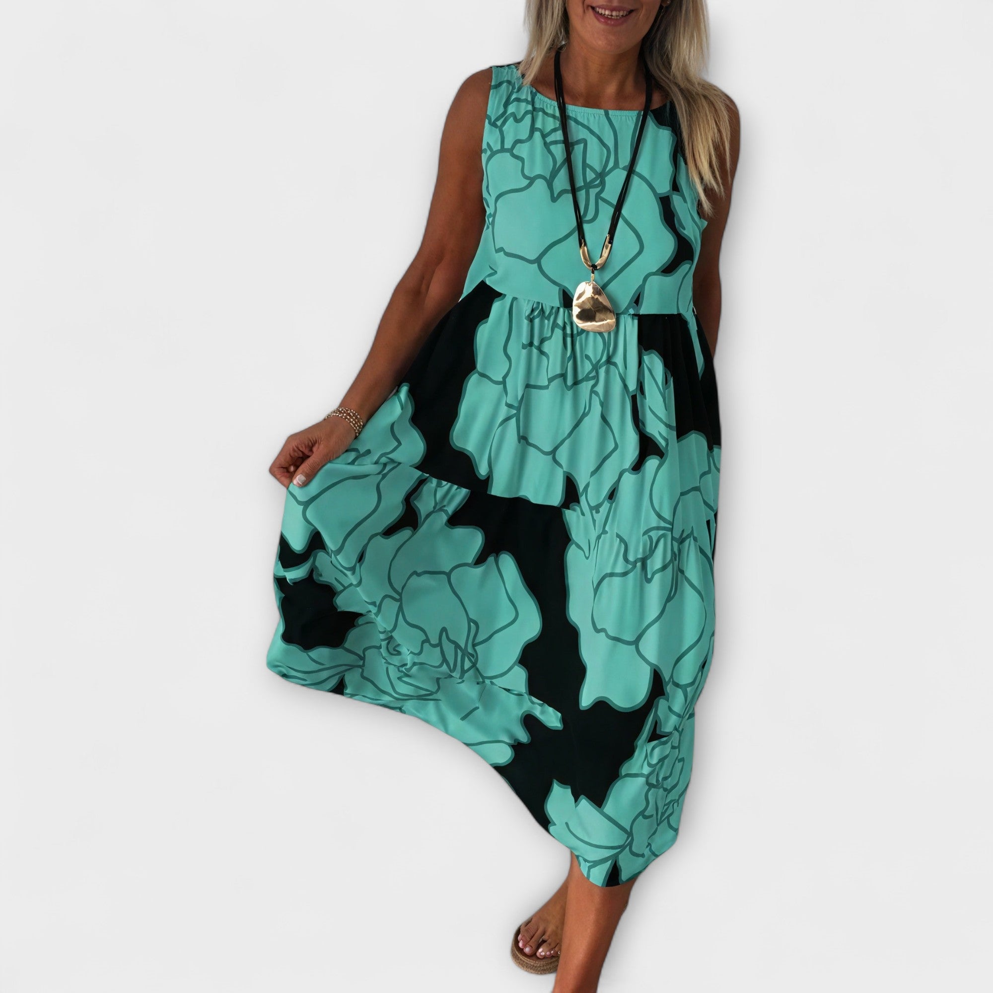 Geblümtes Midi-Kleid, ärmellos, Stufenrock, türkisgrüner Grund mit dunklem Muster