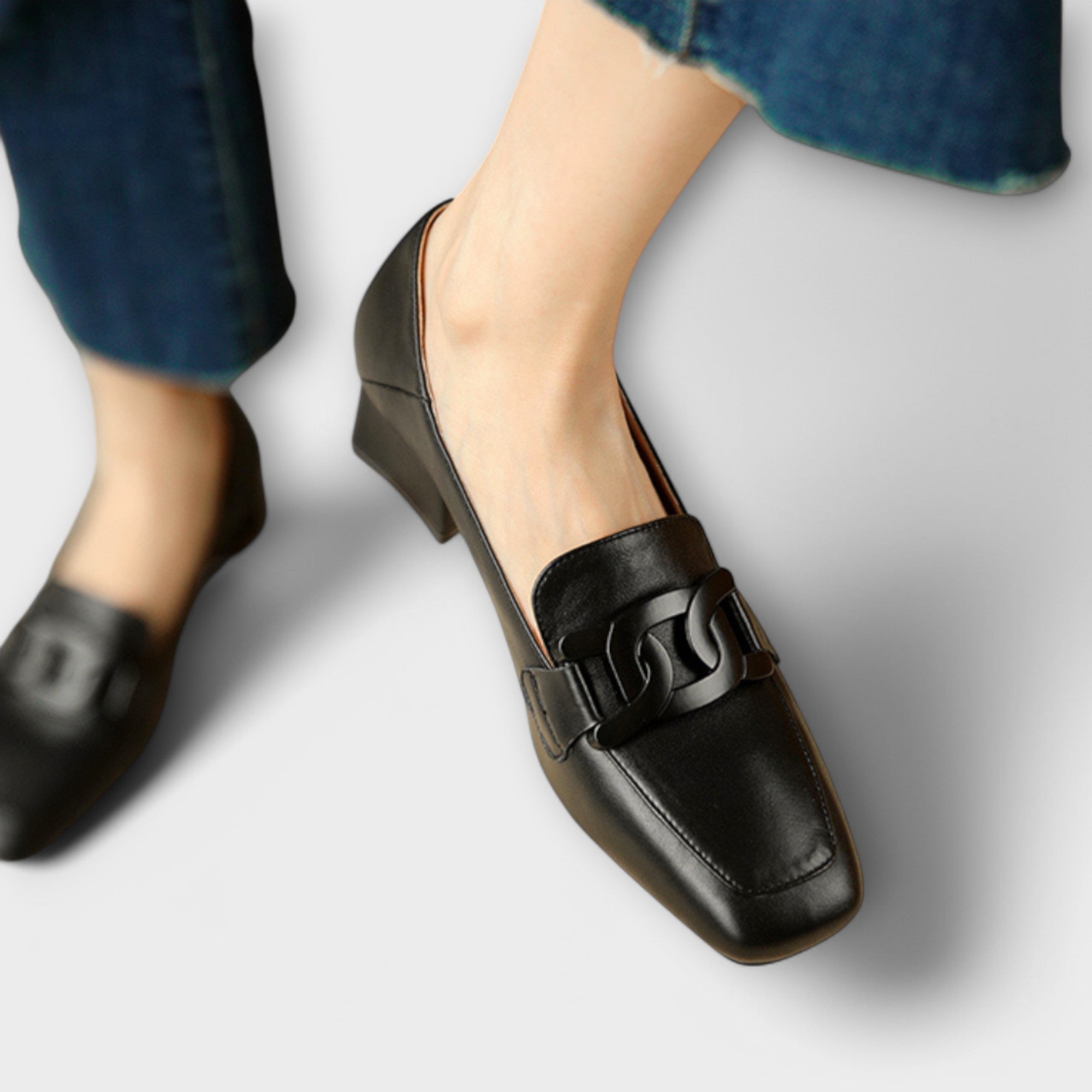 Schwarze Slipper am Fuß mit Blockabsatz und Zierschlaufe vorne