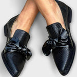 Schwarze Slipper mit Schleifendetail und Schlangenmuster