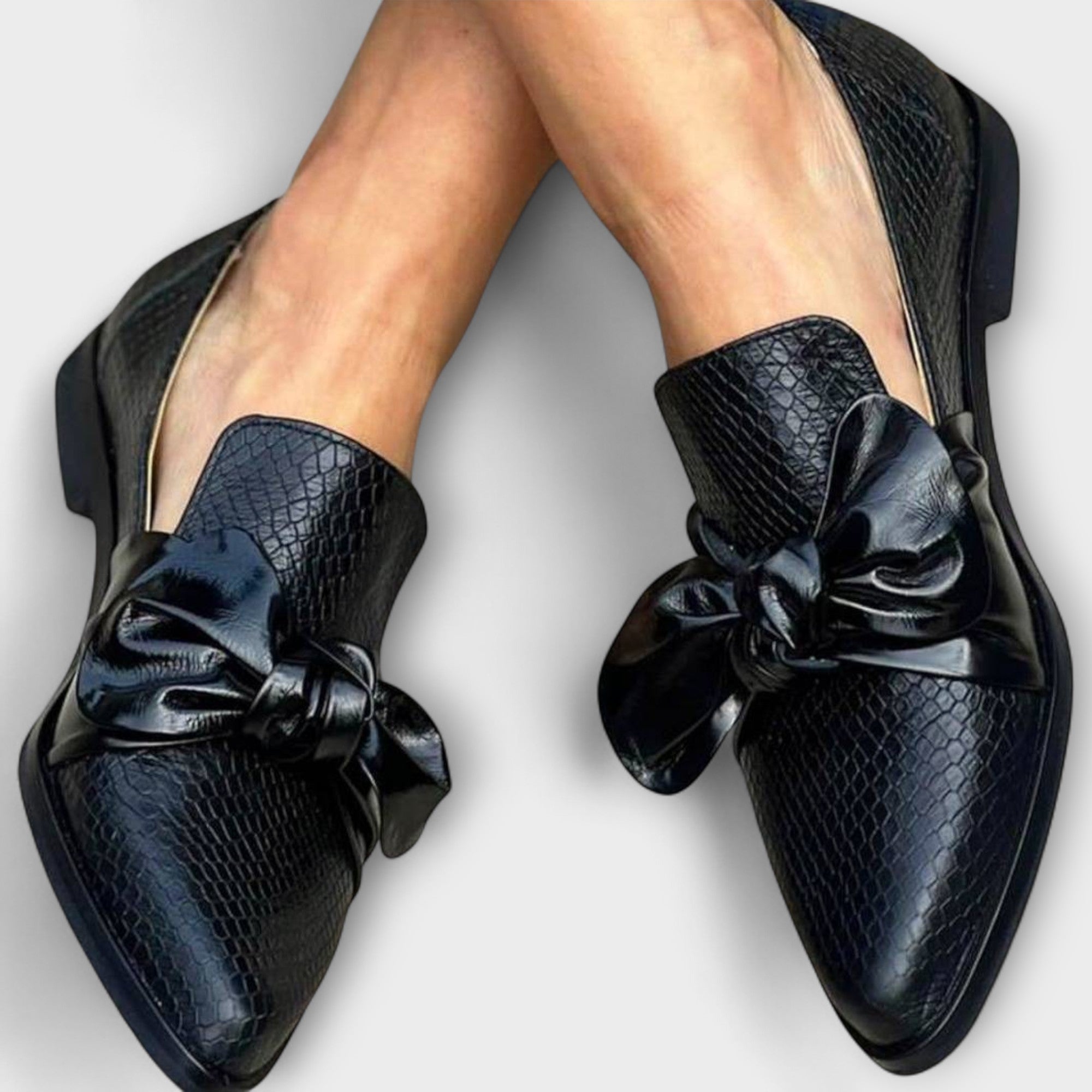 Schwarze Slipper mit Schleifendetail und Schlangenmuster