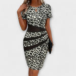Leopardenmuster-Kleid mit kurzem Ärmel und Keyhole-Ausschnitt, schwarze Zierbänder, Midi-Länge.