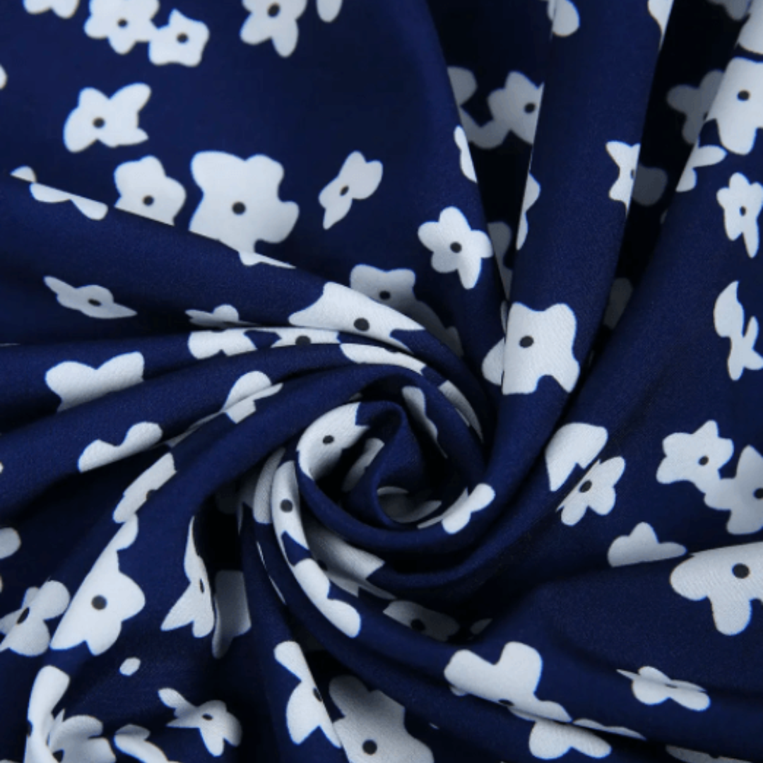 Stoffdetail des Blumenkleids: dunkelblauer Stoff mit weißem Blümchenprint