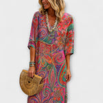 Langes Blumen-Kleid mit V-Ausschnitt, farbenfrohem Muster und kurzen Ärmeln