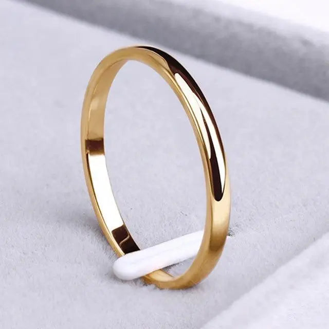 Goldfarbener Ring mit dunkler Einlage im Profil, poliert, schlicht