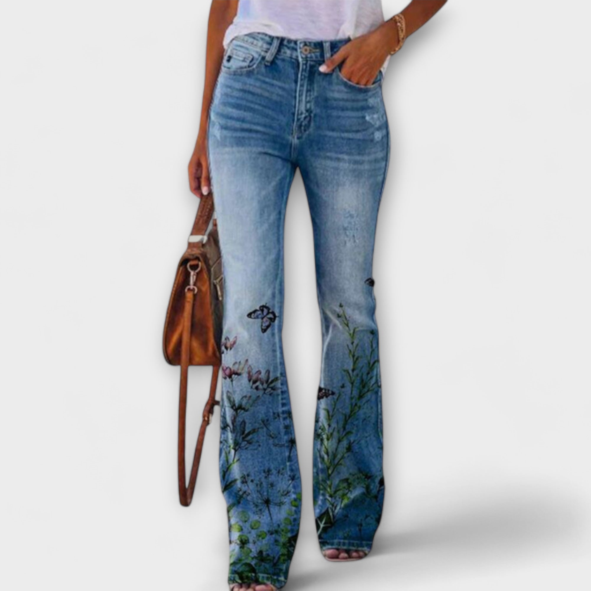 Hose mit weitem Bein aus Jeansstoff, Pflanzen- und Schmetterlingsmotiv am unteren Bein.