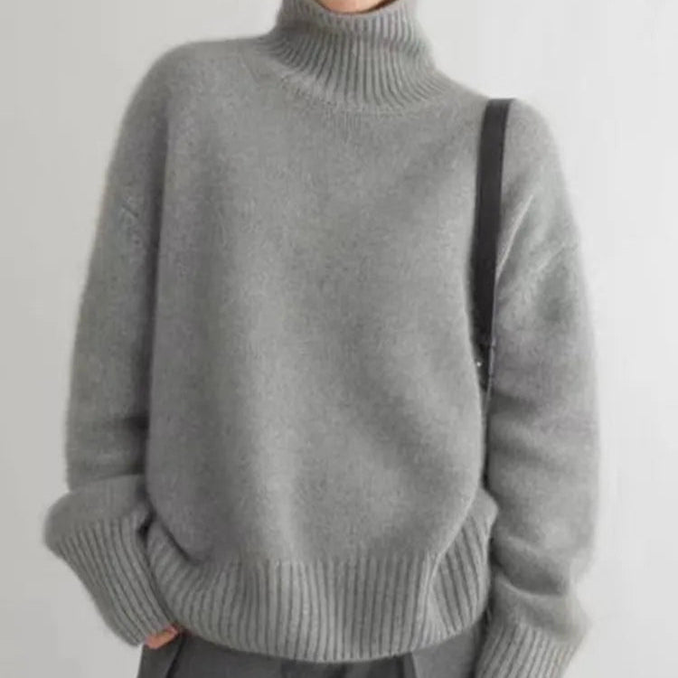 Grauer Rollkragenpullover mit geripptem Kragen, Rippenbündchen und lockerem Schnitt.