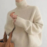 Beiger Rollkragenpullover mit breitem Rollkragen und Rippenmuster an Ärmeln und Saum.