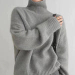 Grauer Rollkragenpullover aus Strick mit hohem geripptem Kragen und breitem Saum.