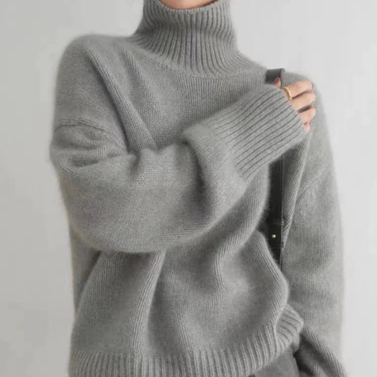 Grauer Rollkragenpullover aus Strick mit hohem geripptem Kragen und breitem Saum.