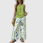 Zweiteiliges Sommeroutfit: grünes ärmelloses Top und weite Hose mit Muster.