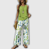 Zweiteiliges Sommeroutfit: grünes ärmelloses Top und weite Hose mit Muster.