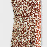 Stoffausschnitt vom Serephina Boho-Maxikleid mit weißem Blumenmuster auf braunem Grund